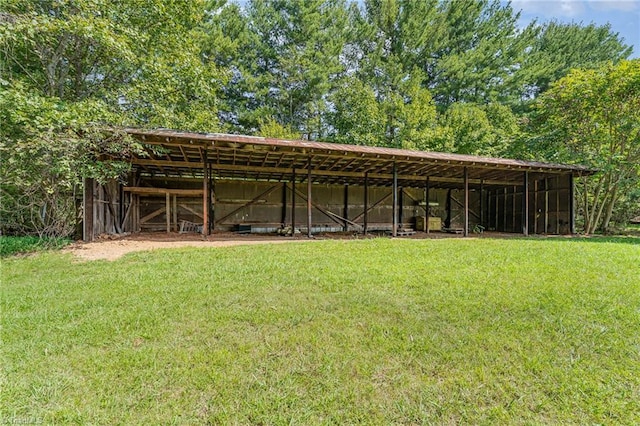 view of pole building with a detached carport and a lawn