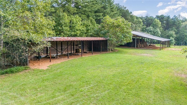 view of yard with a detached carport, an outbuilding, and a pole building