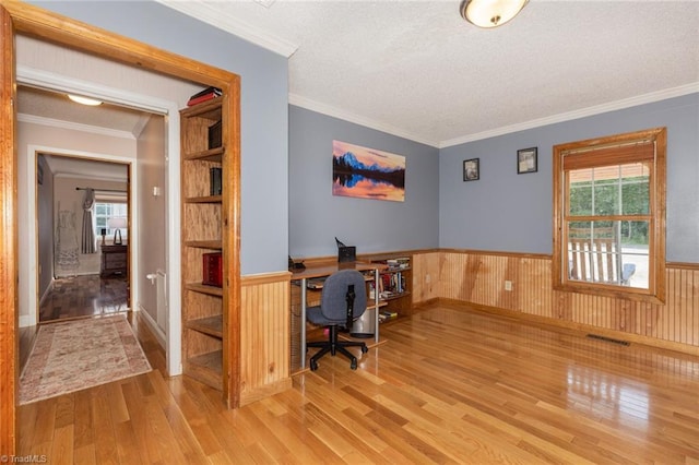 office space with ornamental molding, a wainscoted wall, a textured ceiling, and wood finished floors