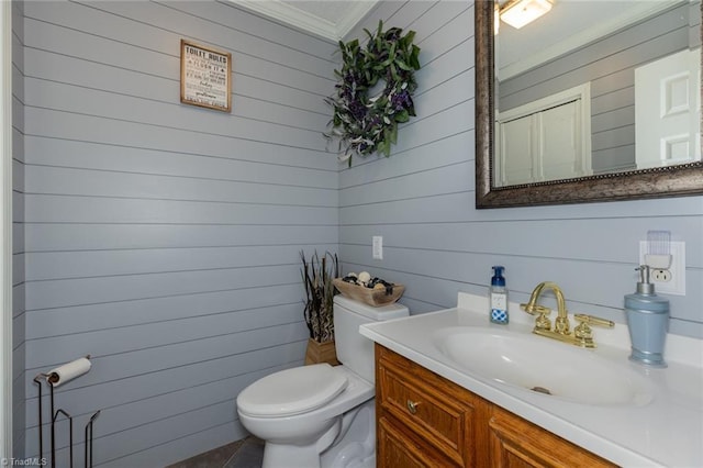 bathroom with ornamental molding, vanity, and toilet