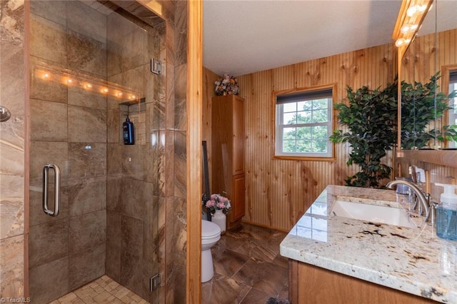 full bath featuring toilet, wood walls, vanity, and a stall shower