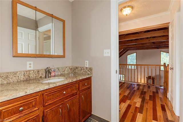 bathroom with lofted ceiling, wood finished floors, and vanity