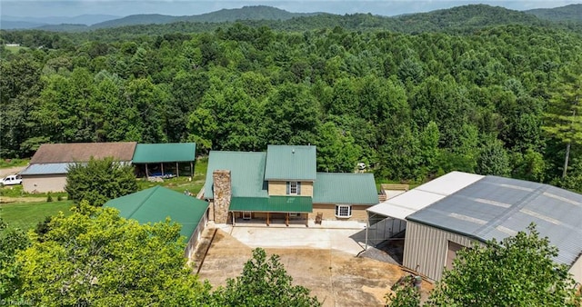 drone / aerial view with a mountain view and a wooded view