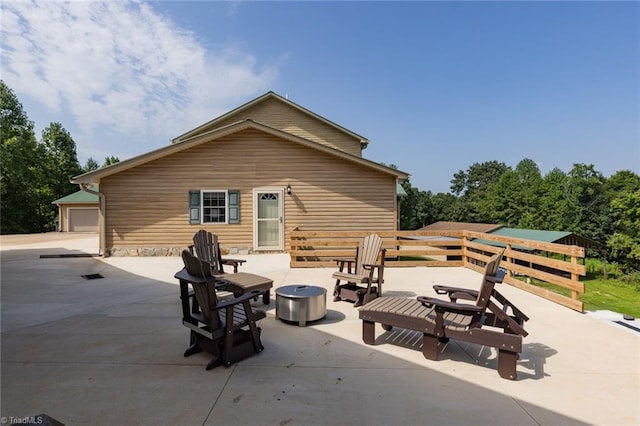 view of patio / terrace featuring a fire pit and an outbuilding