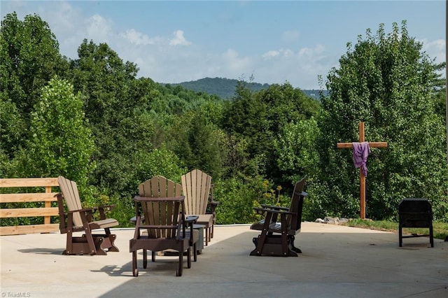 view of community with a patio area and a view of trees