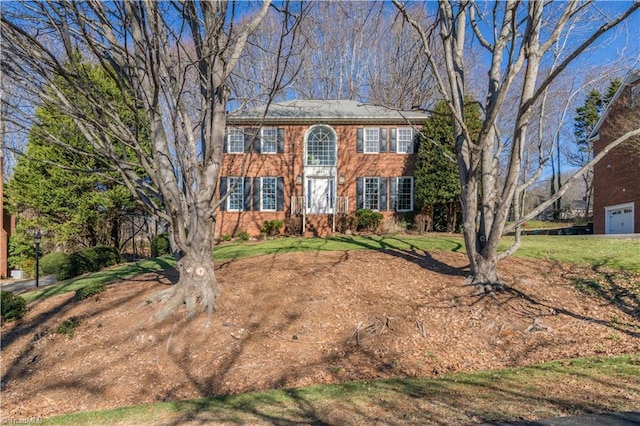 colonial home featuring a front lawn