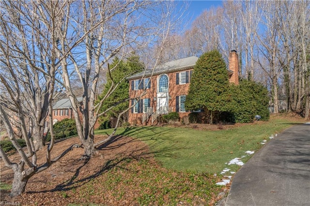 colonial house featuring a front lawn