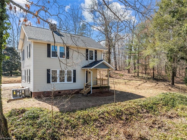 rear view of property featuring crawl space, covered porch, central AC unit, and a chimney