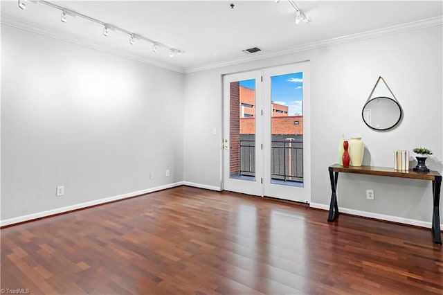 unfurnished room with baseboards, visible vents, wood finished floors, and ornamental molding