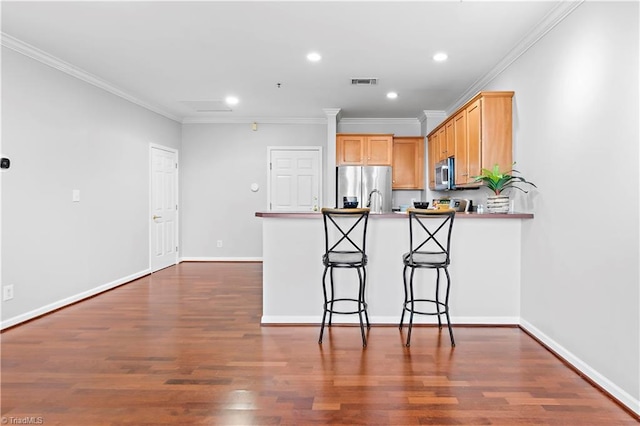 kitchen with dark wood-style floors, stainless steel appliances, a peninsula, and visible vents