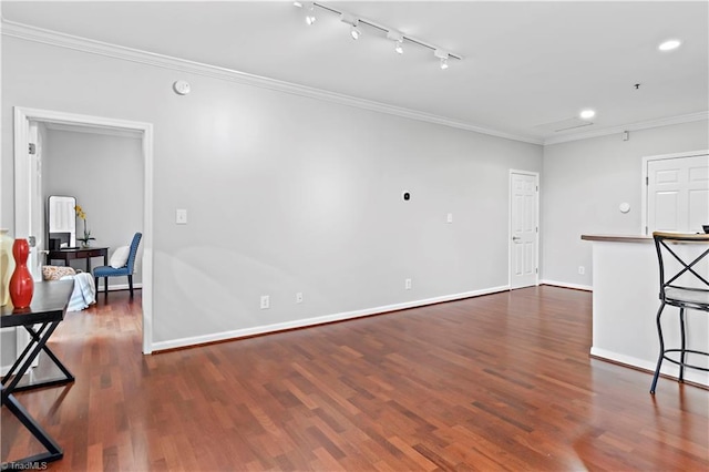 living room featuring dark wood-type flooring, rail lighting, crown molding, and baseboards