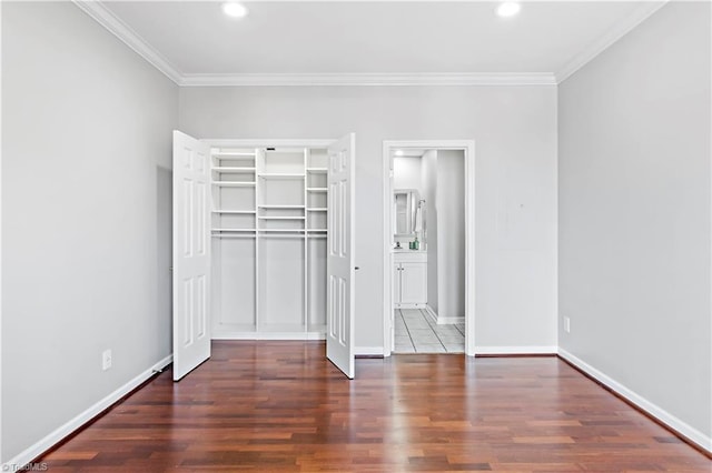 unfurnished bedroom with ornamental molding, a closet, baseboards, and wood finished floors