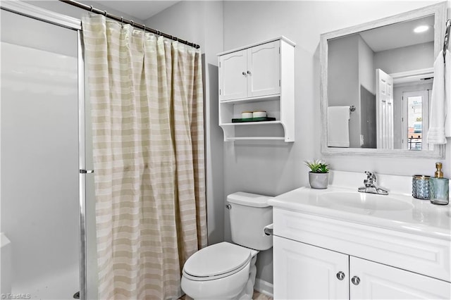 bathroom featuring toilet, vanity, and a shower with shower curtain