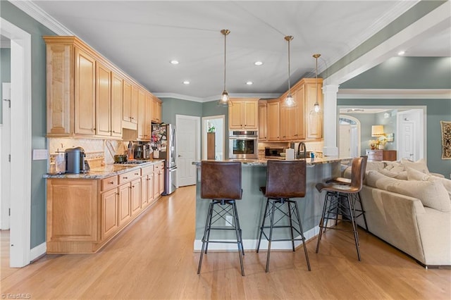 kitchen with pendant lighting, a breakfast bar, light stone countertops, appliances with stainless steel finishes, and kitchen peninsula