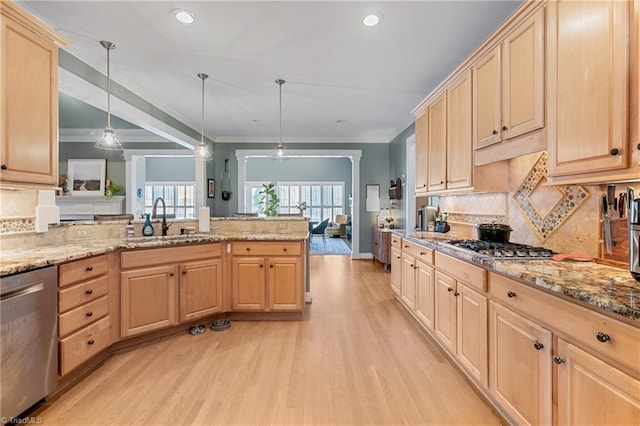 kitchen featuring pendant lighting, light brown cabinets, kitchen peninsula, and appliances with stainless steel finishes