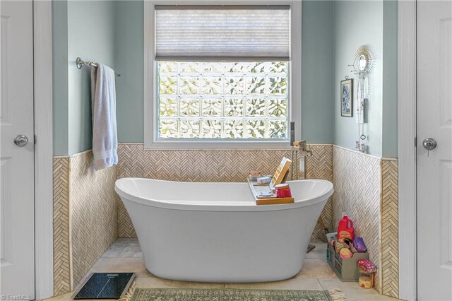 bathroom featuring a washtub, tile walls, and tile patterned flooring