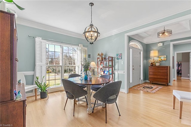 dining room featuring light hardwood / wood-style floors, crown molding, and a chandelier