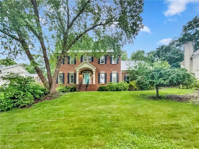 view of front of house with brick siding and a front lawn