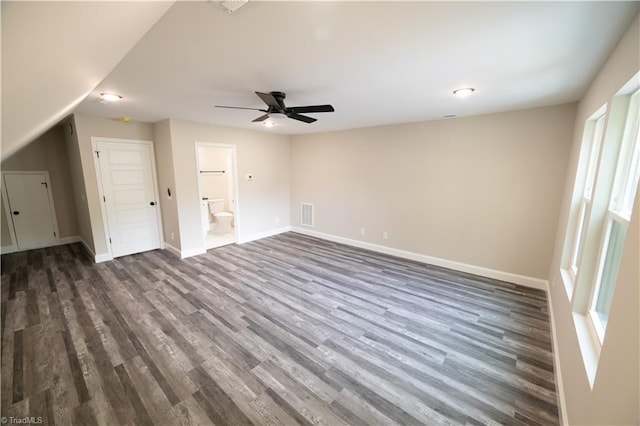 interior space with baseboards, visible vents, ceiling fan, and dark wood-style floors
