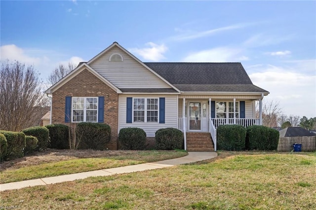 view of front of property featuring covered porch, a front lawn, and brick siding