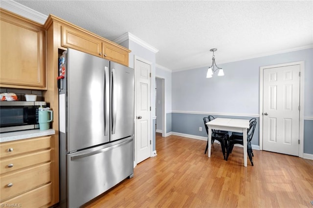 kitchen featuring ornamental molding, stainless steel appliances, a textured ceiling, light countertops, and light wood-type flooring