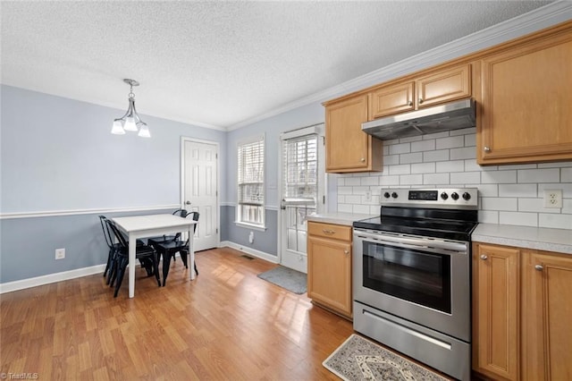 kitchen with light wood-style floors, under cabinet range hood, light countertops, and electric range