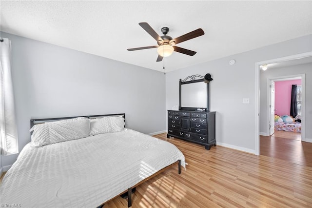 bedroom with baseboards, ceiling fan, and light wood finished floors