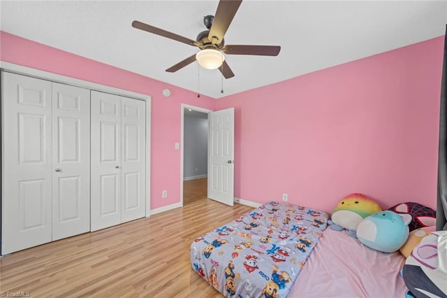 bedroom featuring a closet, ceiling fan, baseboards, and wood finished floors