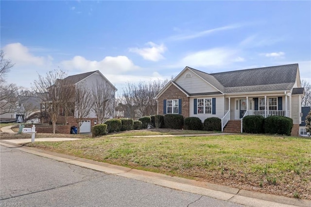 view of front facade with a garage, a front lawn, a porch, and brick siding