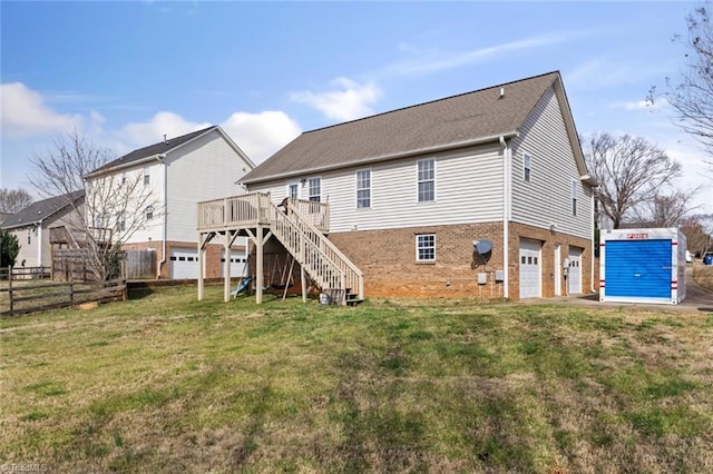 rear view of property with a deck, an attached garage, brick siding, fence, and stairs