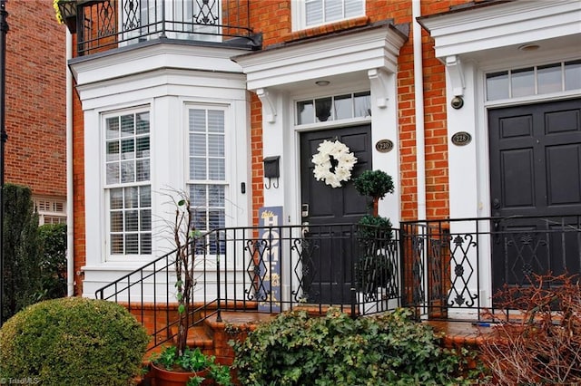 view of exterior entry featuring a balcony