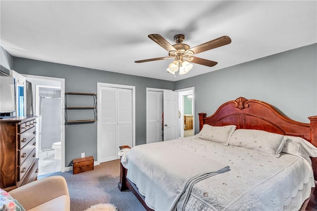 carpeted bedroom featuring two closets, ensuite bath, and ceiling fan