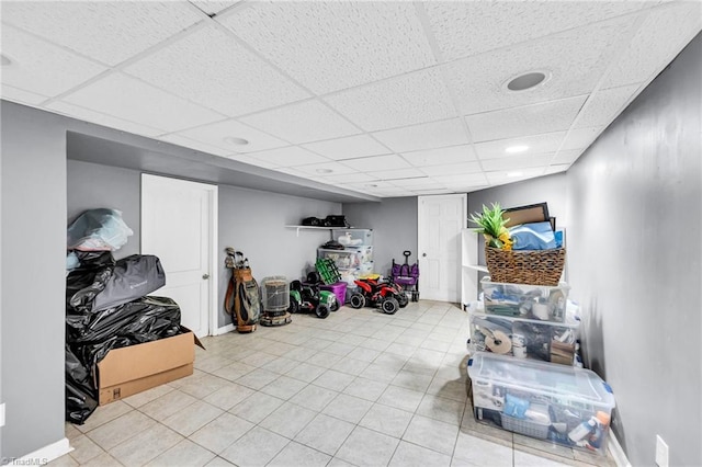 interior space featuring light tile patterned floors and a paneled ceiling