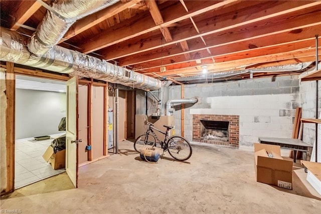 basement with water heater and a brick fireplace