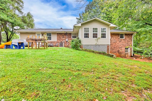 exterior space featuring central AC unit, a wooden deck, and a lawn