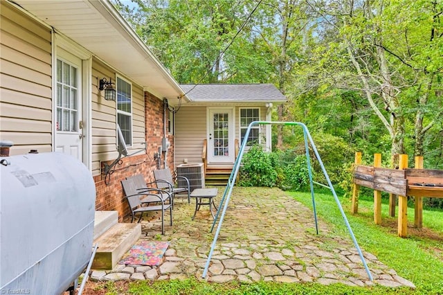 view of patio featuring a playground and central AC unit