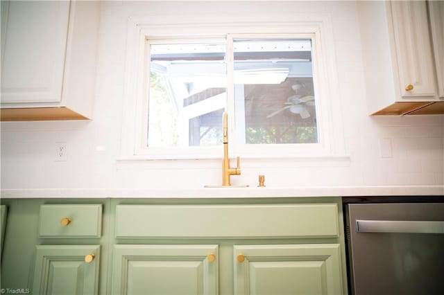 kitchen with backsplash, plenty of natural light, light countertops, and dishwasher