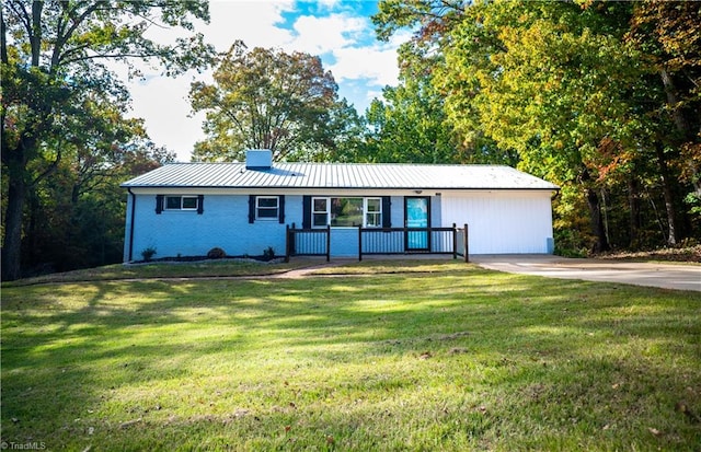 ranch-style home featuring a front yard, a standing seam roof, brick siding, and metal roof