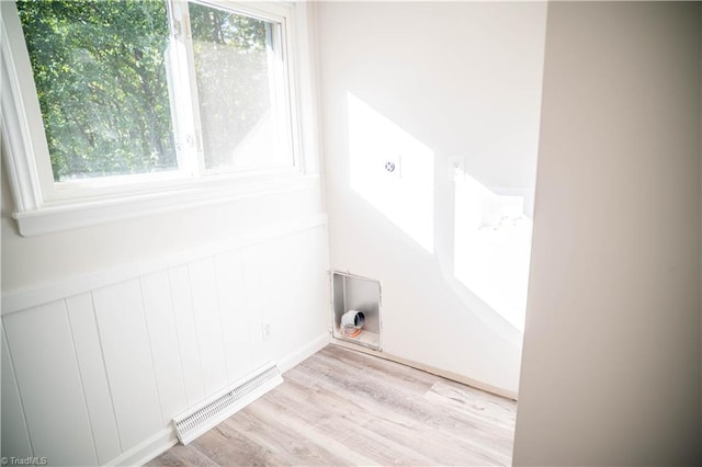 washroom with hookup for an electric dryer, laundry area, visible vents, wainscoting, and light wood finished floors