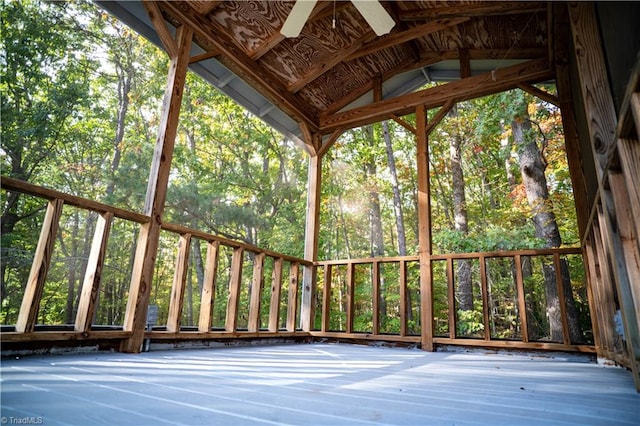 unfurnished sunroom featuring a ceiling fan and vaulted ceiling