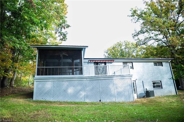 rear view of property with a sunroom, central AC, a lawn, and brick siding