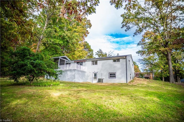 rear view of property featuring a balcony and a yard