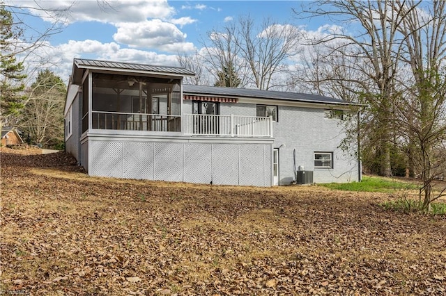 rear view of house featuring a sunroom and brick siding