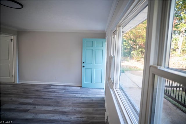 interior space with dark wood-style floors, ornamental molding, and baseboards