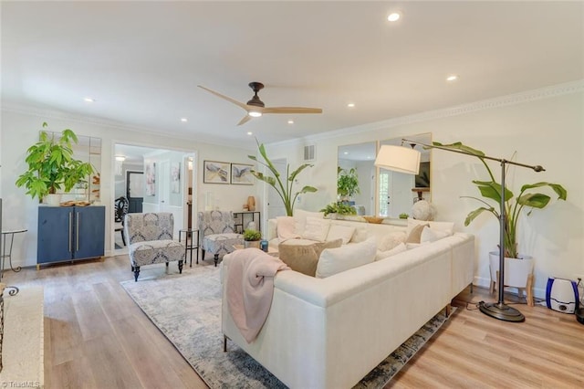 living area with ceiling fan, recessed lighting, light wood-style floors, and ornamental molding