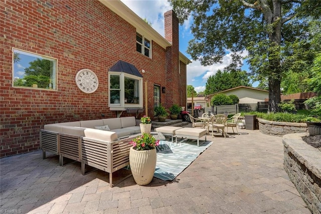 view of patio featuring an outdoor living space, fence, and outdoor dining area
