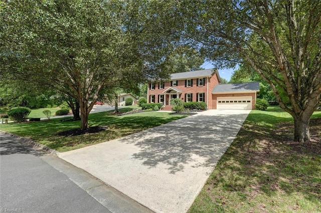 colonial-style house featuring a garage, concrete driveway, a front lawn, and brick siding