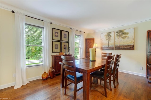 dining area featuring baseboards, dark wood-type flooring, and ornamental molding