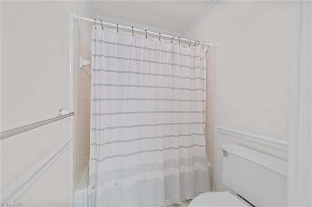 bathroom featuring shower / bath combo, toilet, and crown molding