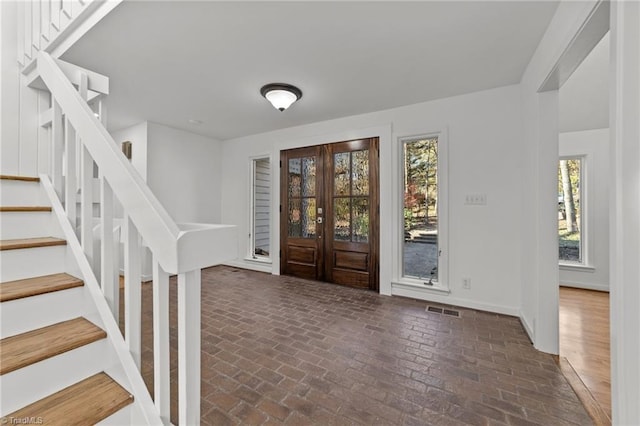 foyer entrance with french doors and a healthy amount of sunlight